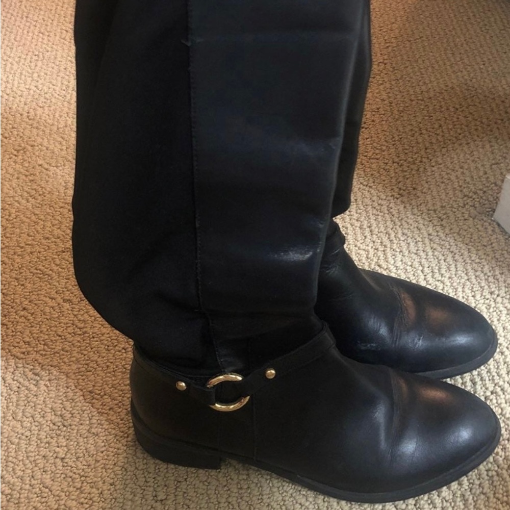 Black boots below the knee with a gold hardware buckle
